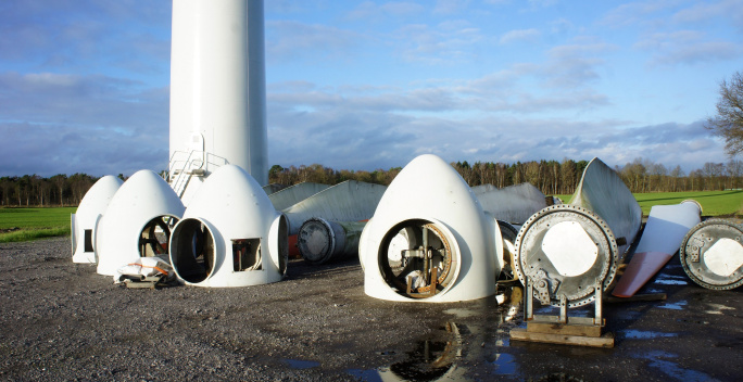 Auf diesem Bild sind verschiedene Einzelteile einer Windkraftanlage zu erkennen.