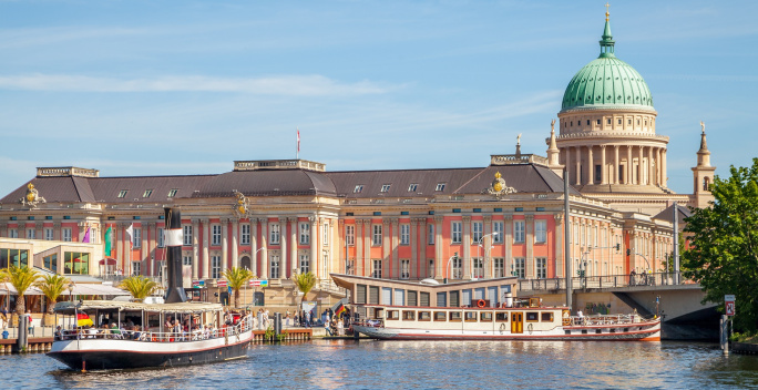 Historische Gebäude Potsdams mit Wasser im Vordergrund und Ausflugsschiffen