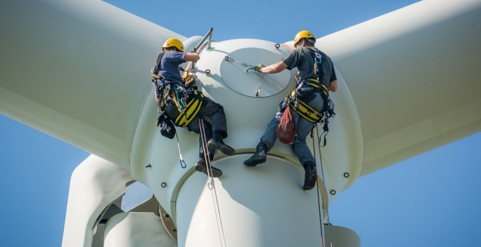 Auf diesem Bild erkennt man zwei Männer, die an einem Rotor arbeiten.