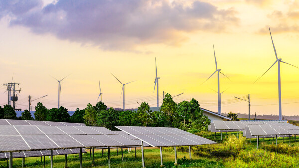 Photovoltaikanlagen mit einem Stromnetz und Windkraftanlagen im Hintergrund